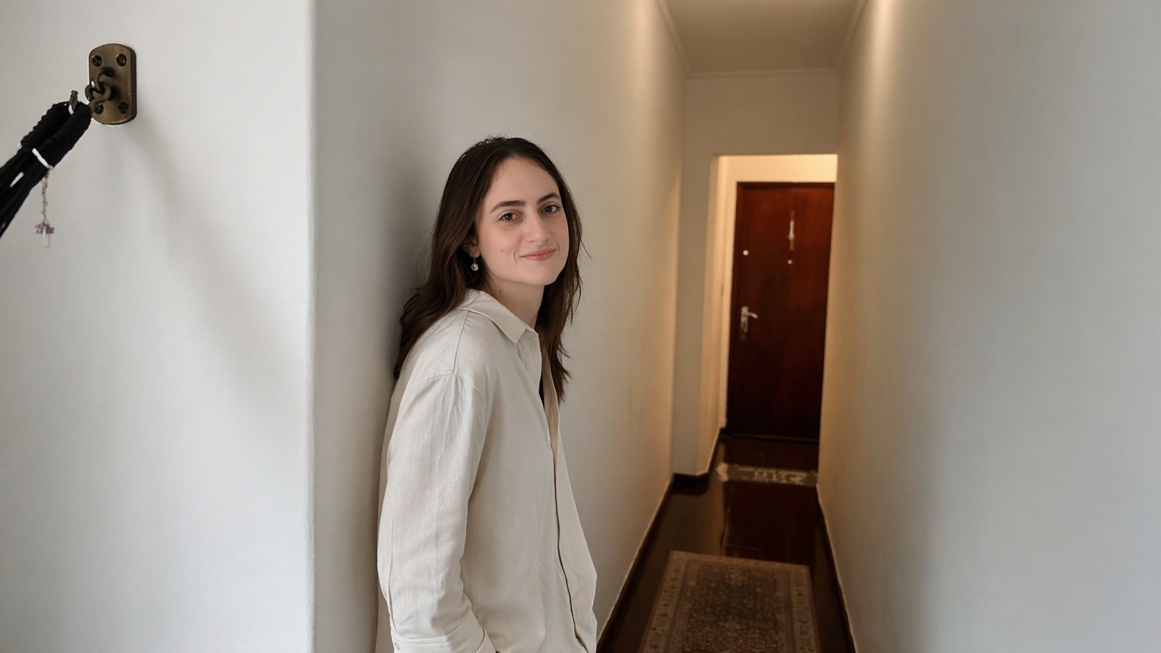 Dra. Isadora Alvarez sorrindo, encostada em uma parede.